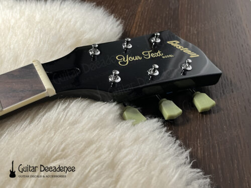 black gibson style guitar headstock with metallic gold waterslide decal