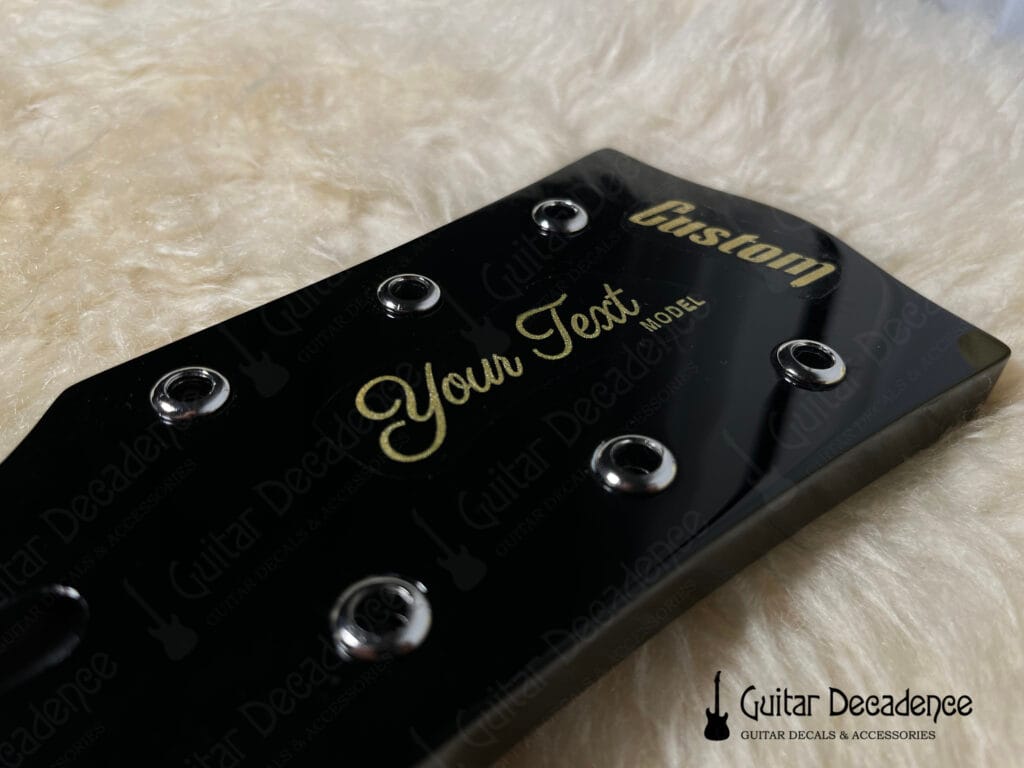 black gibson style guitar headstock with metallic gold waterslide decal