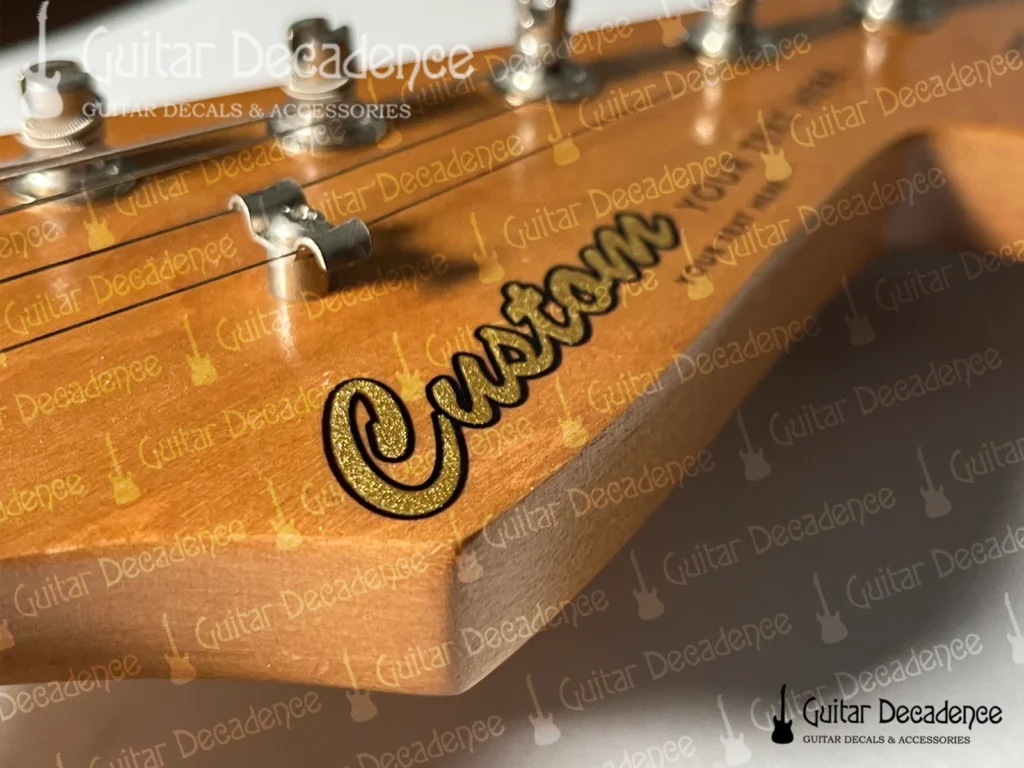 Close up of classic metallic gold guitar decal on a stratocaster style headstock