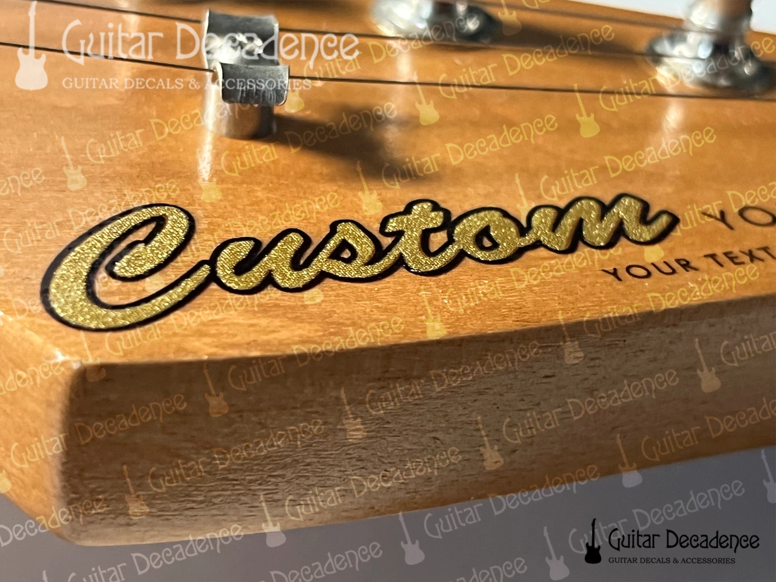 Close up of classic metallic gold guitar decal on a stratocaster style headstock