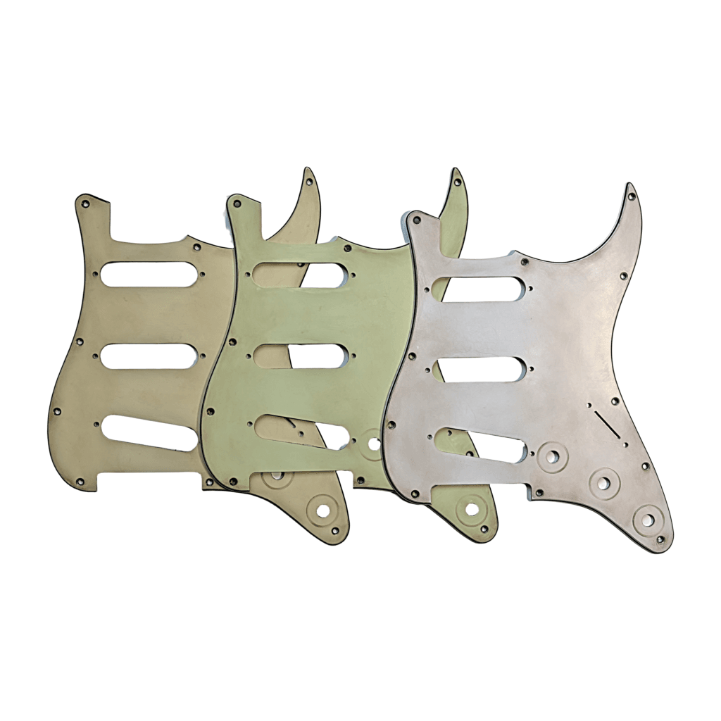 Aged pickguards for stratocaster guitars in mint green, cream, and white.