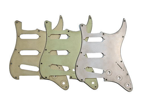 Aged pickguards for stratocaster guitars in mint green, cream, and white.